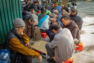 Vietnamlı erkekler Hanoi, Vietnam 'ın merkezindeki kaldırımda Çin satrancı oynuyorlar..