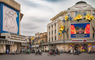 Hang Bai ve Trang Tien kavşağında gri bir kış günü Trang Tien Plaza 'nın yanındaki motosiklet ve araba trafiği, Hanoi, Vietnam.