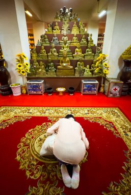 A woman prays at a Buddhist shrine within Phnom Preah Reach Troap at Oudong Temple in Kandal Province near Phnom Penh, Cambodia. clipart