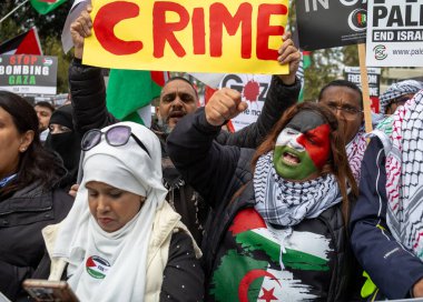 Londra / İngiltere - 21 Ekim 2023: Filistin bayrağı rengine boyanmış kadın bir Filistinli protestocu, İsrail 'in Londra, İngiltere' deki Gazze saldırılarına karşı düzenlenen toplu gösteride bağırdı.