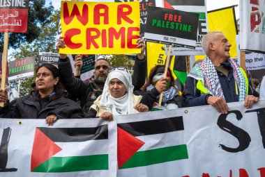 Londra / İngiltere - 21 Ekim 2023: Filistin yanlısı protestocular, İsrail 'in Londra' nın merkezinde Gazze 'ye düzenlediği saldırılara karşı düzenlenen bir gösteride pankart ve pankart tutuyorlar..