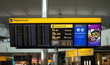 Londra Heathrow Havaalanı, İngiltere 'deki Terminal 2' de kalkış ve bilgileri gösteren aydınlatılmış bir bilgi panosu.