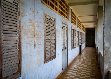 Kamboçya 'nın Phnom Penh kentindeki ünlü Tuol Sleng S-21 işkence ve soykırım hapishane müzesinin eski sınıflarının önünden geçen bir koridor.