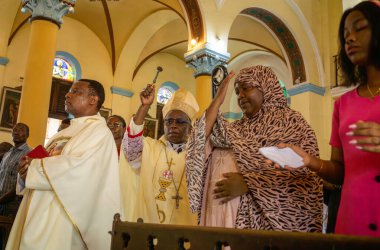 Catholic Bishop Augustine Shao blesses worshippers at the start of Sunday Mass in St Joseph's Cathedral, Stone Town, Zanzibar, Tanzania. clipart