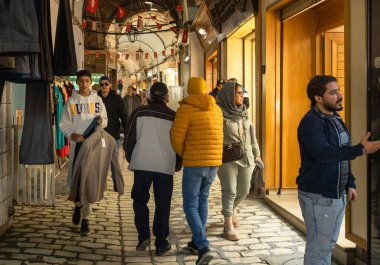 Sousse, Tunus 'un antik Medine' sindeki kapalı çarşıda alışveriş yapanlar. Medine UNESCO 'nun Dünya Mirası Bölgesi.