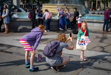 Londra, Trafalgar Meydanı 'nda Union Bayraklarını tutan genç bir kız annesinin fotoğrafını çekerken dilini uzatıyor..