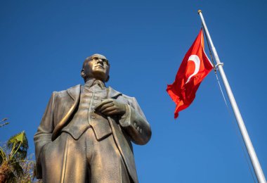 Çağdaş Türkiye 'nin kurucusu Mustafa Kamal Atatürk' ün büyük bronz heykeli, Türkiye 'nin Antalya ilindeki Side Old Town' da bir meydanda Türk bayrağını dalgalandıran bir bayrak direğinin yanında duruyor (Türkiye))