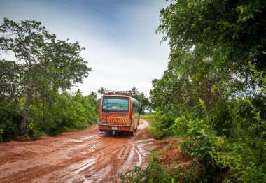 Tanzanya kırsalında Cholesamvula yakınlarında ıslak ve çamurlu bir toprak yoldan geçen bir halk otobüsü.