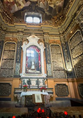 Arranged skulls, bones and paintings in the ossuary inside Chiesa di San Bernardino alle Ossa (Church of St. Bernardine of the Bones), Milan, Italy clipart