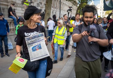 Hükümete karşı komplo teorisyenleri tarafından Londra, Whitehall 'da düzenlenen bir gösteride bir kadın komplo teorisyeni gazetesi 