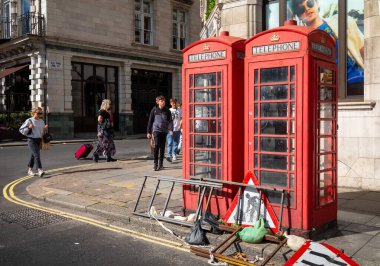 Londra 'nın orta kesimindeki Piccadilly' de yol çalışması tabelalarının yanında solmuş ve harap olmuş ama hala çalışan geleneksel kırmızı telefon kutuları var..