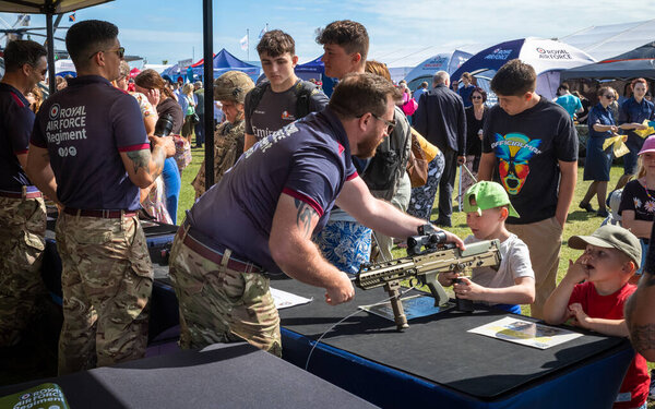 A young boy is shown a SA80 assault military rifle by a soldier from the RAF Regiment at a display stand in the military exhibition alongside the annual Eastbourne Airbourne, an international airshow