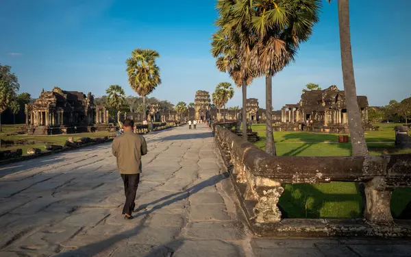 stock image A local man walks along the causeway towards the West Gate at the famed ancient temple of Angkor Wat in Cambodia.