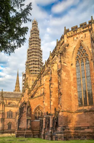 stock image Looking westwards from the rear of Lichfield Cathedral in Staffordshire, UK, with a view of the tall central spire clad in scaffolding while renovations are carried out