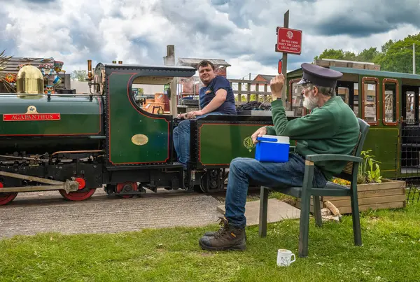 stock image A volunteer drives The Railway Mission minature steam locomotive past a guard  at South Downs Light Railway, Pulborough, UK