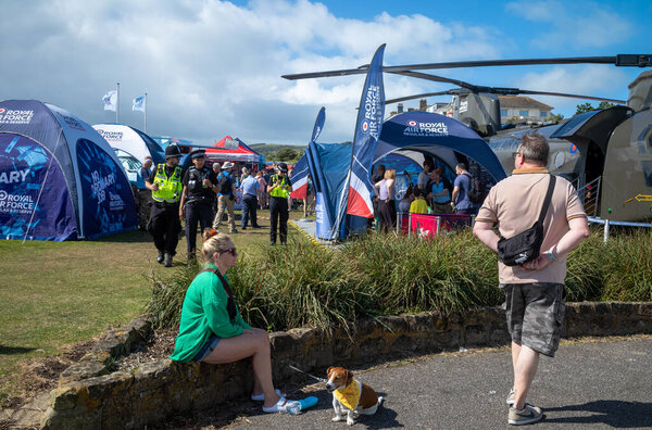 A woman rests with her small dog at the military exhibition alongside the annual Eastbourne Airbourne, an international airshow