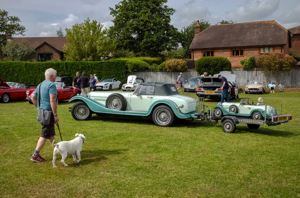 stock image A man with a dog walks near a classic Durow Cars 