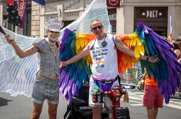 stock image London / UK - Jun 29 2024: Two gay men in elaborate costumes at the annual Pride in London parade. The celebration brings together people from LGBTQ+ communities.