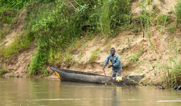 Bir adam, Mwaseni 'deki Rufiji Nehri' nde, Tanzanya 'daki Nyerere Ulusal Parkı' nda (Selous Game Reserve) balık tutmaya hazırlanırken, yedek kanosunda duruyor..