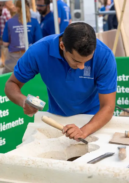 stock image A skilled stonemason works on a new gothic-style stone carving to be used on Notre Dame Cathedral in Paris, France, which is being rebuilt after a devastating fire.