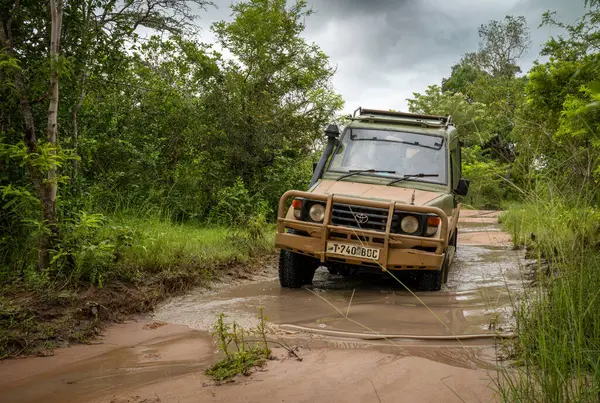 stock image A 4x4 vehicle drives along a flooded track on safari inside Nyerere National Park (Selous Game Reserve) in Tanzania.