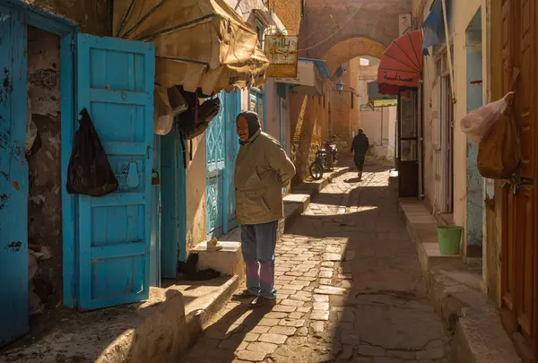Yaşlı bir adam, İslam 'ın dördüncü en kutsal şehri olan Kairouan, Tunus' un eski Medine 'sinde dar bir sokakta duruyor..