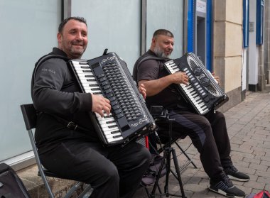 Newbury, Berkshire, İngiltere 'nin merkezindeki Northbrook Caddesi' nde akordeon çalan iki göçmen sokak müzisyeni.