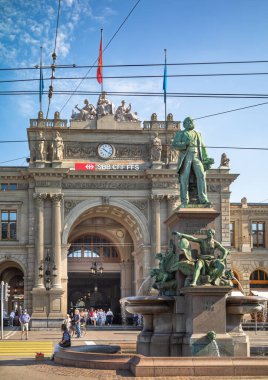 Demiryolu Kralı Alfred Escher 'in heykeli, İsviçre' nin en ikonik tren istasyonlarından biri olan Zürih HB 'nin Neo-Rönesans cephesinin önünde..