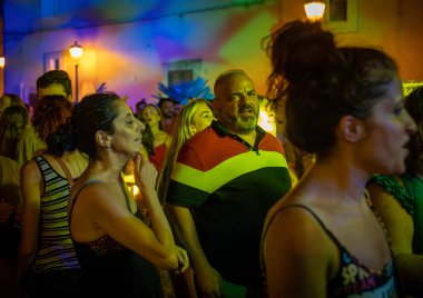 İtalya 'nın Apulia kentindeki bir köy olan Depressa' daki meydanda gece yarısı açık hava konseri veren bir İtalyan kalabalığında bir karı koca..