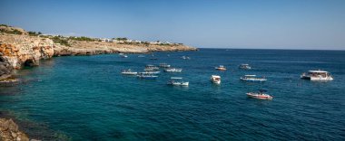 İtalya 'nın Apulia eyaletindeki Santa Maria di Leuca yakınlarındaki mağara girişlerinde turistik gezi tekneleri bir araya geldi.