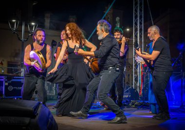 Mauro Durante (Rear) ve grubu Canzoniere Grecanico Salentino, veya CGS, Alessano, Lecce Eyaleti, Apulia, İtalya 'da sahne aldı. Grup pizza veya Salento halk müziği icra eder..