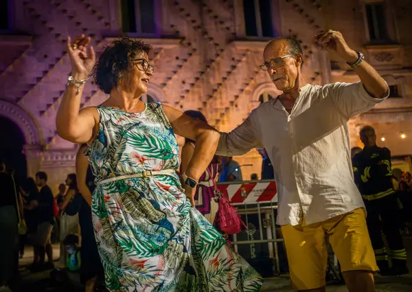 stock image People enjoy Pizzica dance at a concert by Canzoniere Grecanico Salentino, or CGS, in Alessano, Lecce Province, Apulia, Italy. The band perform traditional pizzica, or Salento folk music.