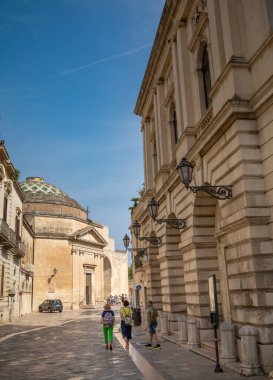 Turistler Giuseppe Palmieri Vadisi 'nden geçerek İtalya' nın antik Lecce kentindeki Napoli Kapısı 'nın yanındaki Saint Mary della Porta Kilisesi' ne doğru yürür..