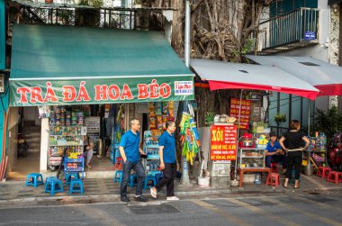 İki adam Hanoi, Vietnam 'daki Yen Phu Caddesi' nde buzlu çay ve bakkal satarak küçük bir dükkandan çıktılar.