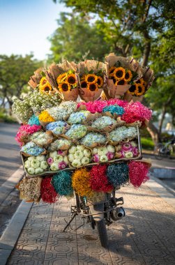 Nilüfer çiçekleri (Nelumbo nucifera), ortanca (Hydrangeaceae), ayçiçekleri (Helianthus) ve diğer çiçekleri Hanoi, Vietnam 'da bir motosiklette satılığa çıkarıldı..