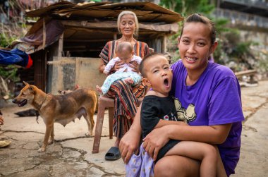 Hanoi, Vietnam 'daki Long Bien köprüsünün altında, sele eğilimli bir bölgede yaşayan, çocuklu yoksul bir anne ve büyükanne..