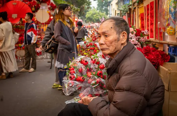 Yaşlı Vietnamlı bir adam Tet veya Ay Yeni Yılı satıyor, Hang Ma 'da madalyalar, Hanoi, Vietnam' da.
