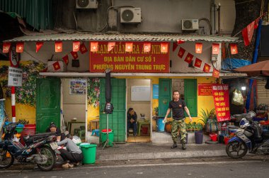 Hanoi, Vietnam 'daki Nguyen Trung Truc Bölgesi Yerel Güvenlik Devriye Ofisi' nin önünde duran bir memur, yerel güvenlik ve kamu düzeninden sorumludur..