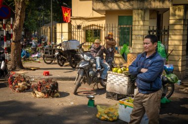 Chau Long Market, Hanoi, Vietnam yakınlarındaki bir sokakta hindistan cevizi, meyve ve canlı tavuk satan adamlar..