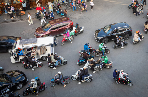 Вид сверху на движение, включая электрический экскурсионный автобус, мотоциклы и автомобили в центре Ханоя, Вьетнам