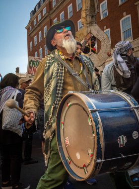 Filistinli bir protestocu Gazze 'de büyük bir barış gösterisinde davul çalıyor ve İsrail ordusuna karşı. Londra, İngiltere.