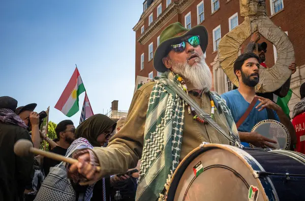 Filistinli bir protestocu Gazze 'de büyük bir barış gösterisinde davul çalıyor ve İsrail ordusuna karşı. Londra, İngiltere.