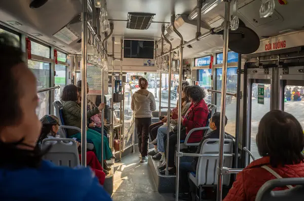 Vietnam, Hanoi şehir merkezinde bir halk otobüsüyle seyahat eden Vietnamlı yolcular..