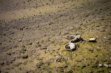 Bir Lime-E elektrikli yardım bisikleti, ya da Londra Hammersmith Köprüsü yakınlarındaki Thames nehrinin kıyısında terk edilmiş bir limon bisikleti. Bu model 2018-2022 yılları arasında kullanıldı..