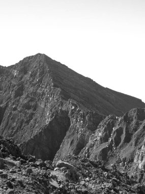 Kayalık bir zirvesi ve kayalık bir yamacı olan bir dağ. Dağ kayalarla kaplı ve o çok dik.