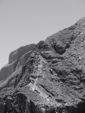 Kayalık yüzeyi ve açık mavi gökyüzü olan bir dağ.