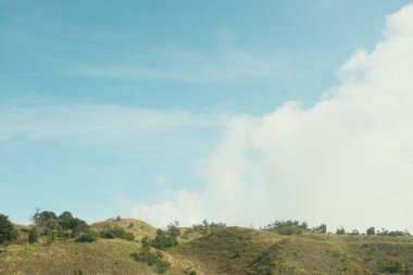Mavi gökyüzü olan bir yamacın bulanık fotoğrafı. Gökyüzü açık ve güneş parlıyor.