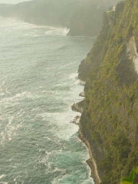 Kayalık bir uçurum okyanusa bakar ve dalgalar ona çarpar. Sahne sakin ve huzurlu, dalgaların sesi ve suyun görüntüsü rahatlatıcı bir atmosfer yaratıyor.