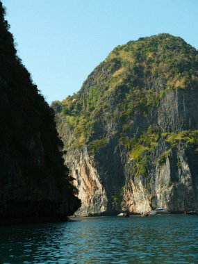 İçinden nehir akan bir dağ sırası. Su sakin ve berrak. Dağlar yemyeşil ve gür