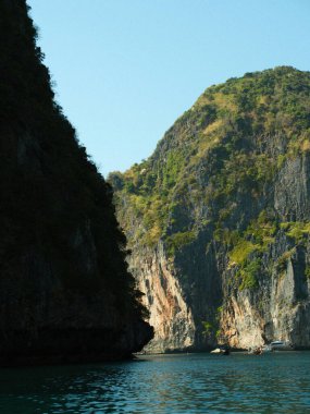 İçinden nehir akan bir dağ sırası. Su sakin ve berrak. Dağlar yemyeşil, gökyüzü mavidir.